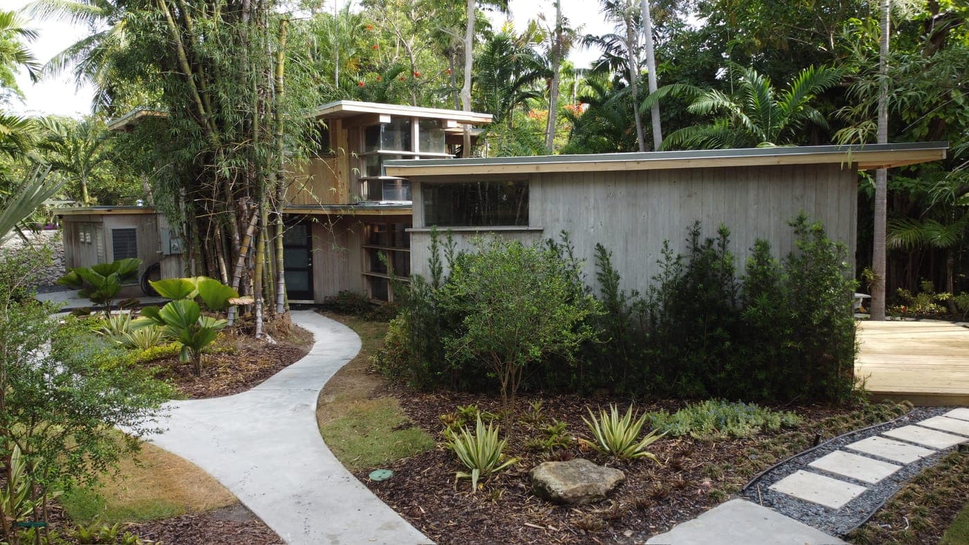 Alfred Browning Parker tropical modernist home. The house from the side, low horizontal roofline against dense planting.