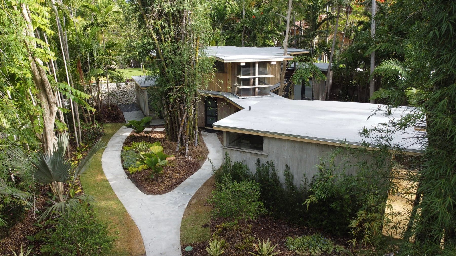 Aerial view of the 1953 Alfred Browning Parker tropical modernist home set in a lush bamboo landscape.