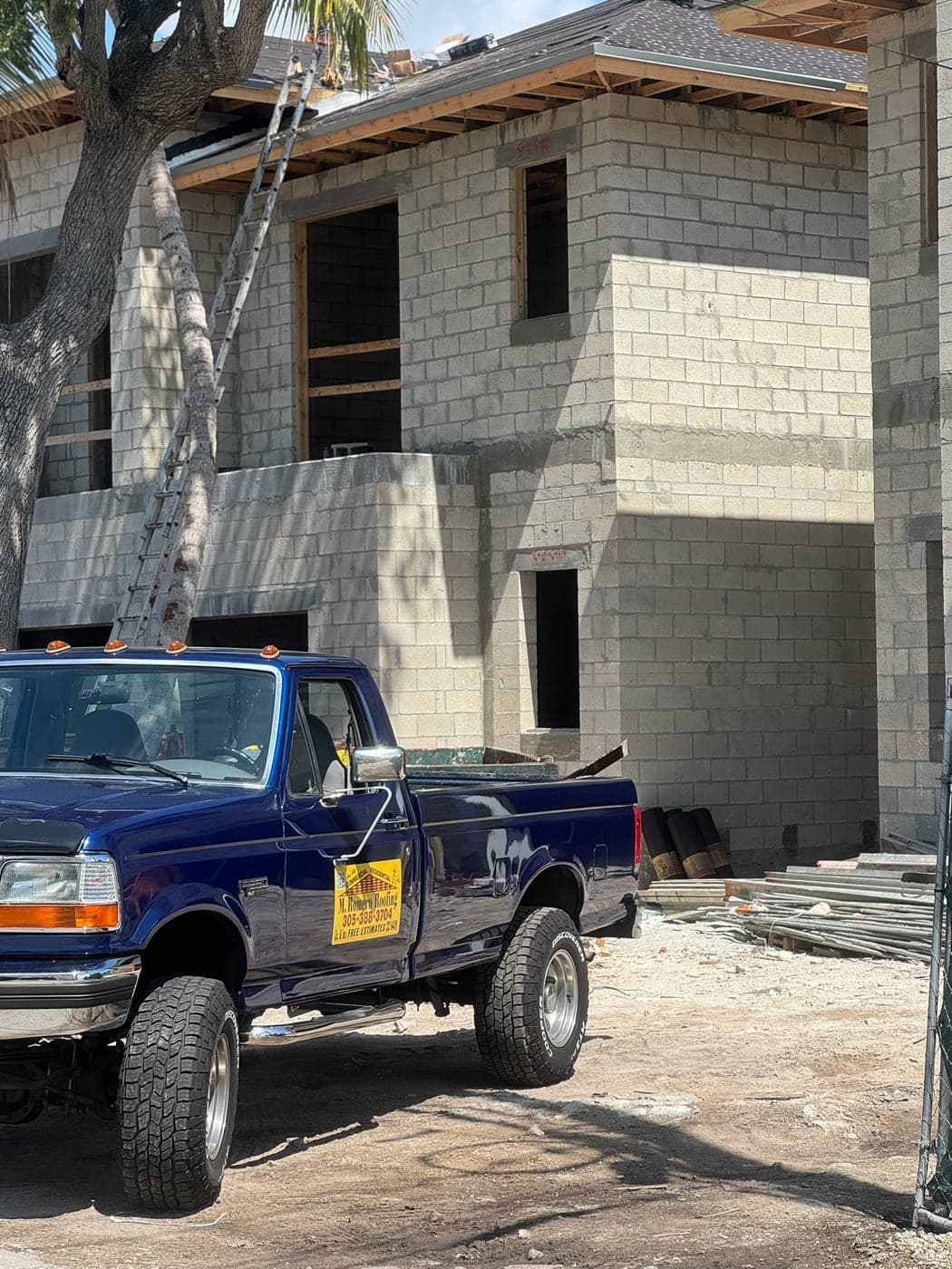 Una camioneta estacionada frente a una casa de bloque en construcción.