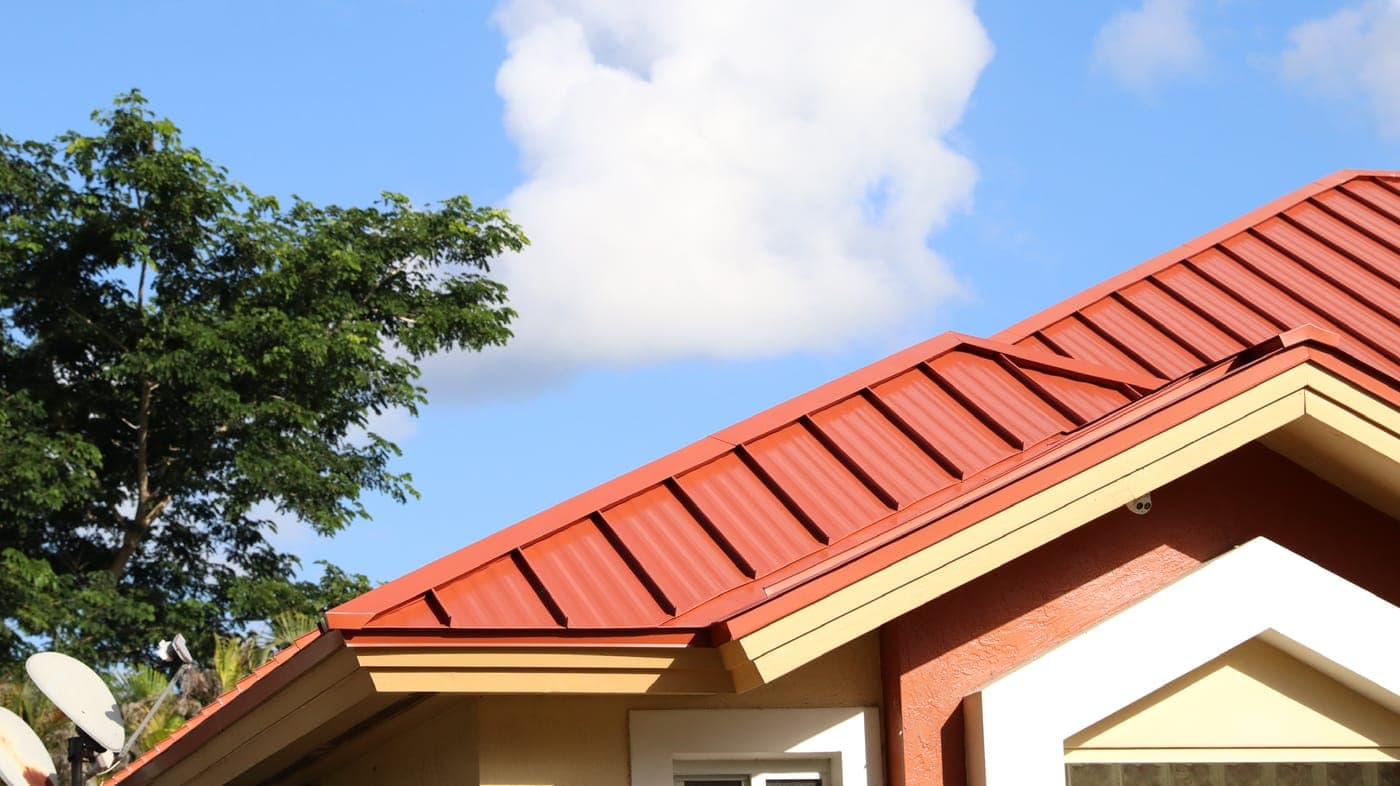 A newly installed red standing-seam metal roof by M. Romero's Roofing.